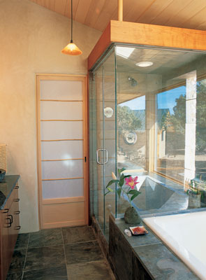 The bathroom contains both a tub and a shower, with view of the outdoors and natural light